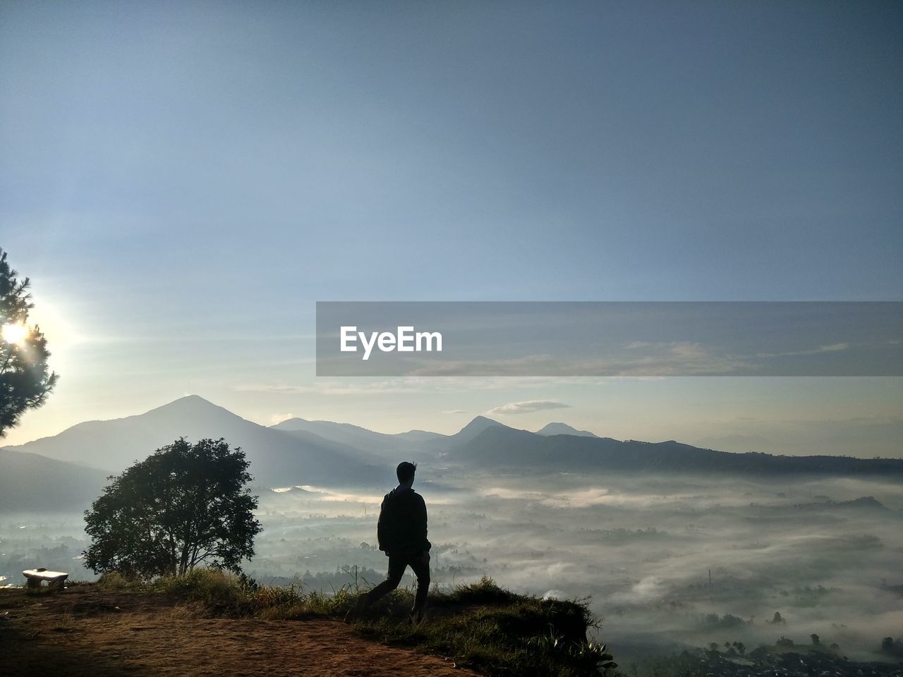 Hiker walking on mountain against sky during sunset