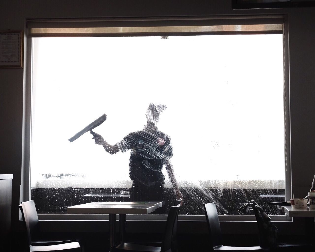 Worker cleaning glass window