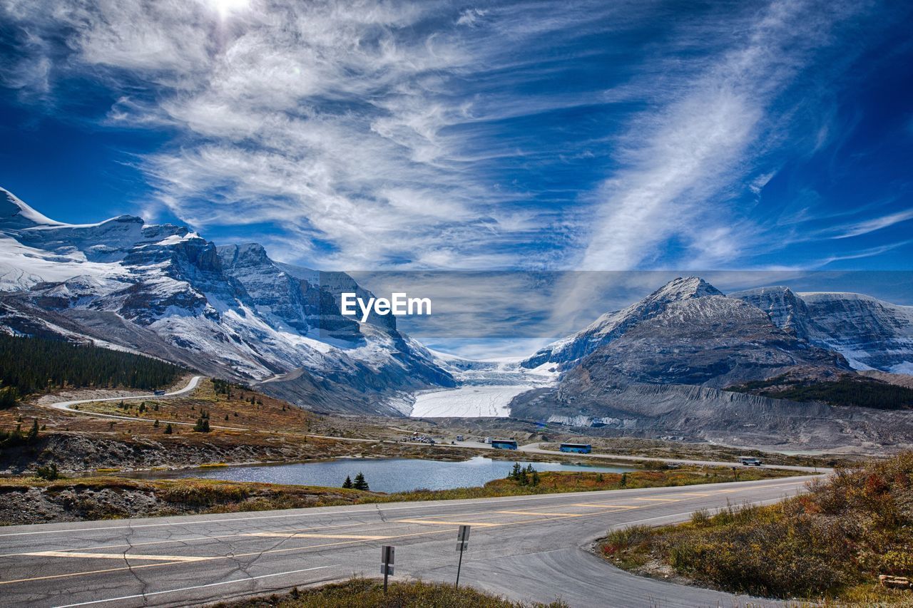 Scenic view of landscape and sea against blue sky