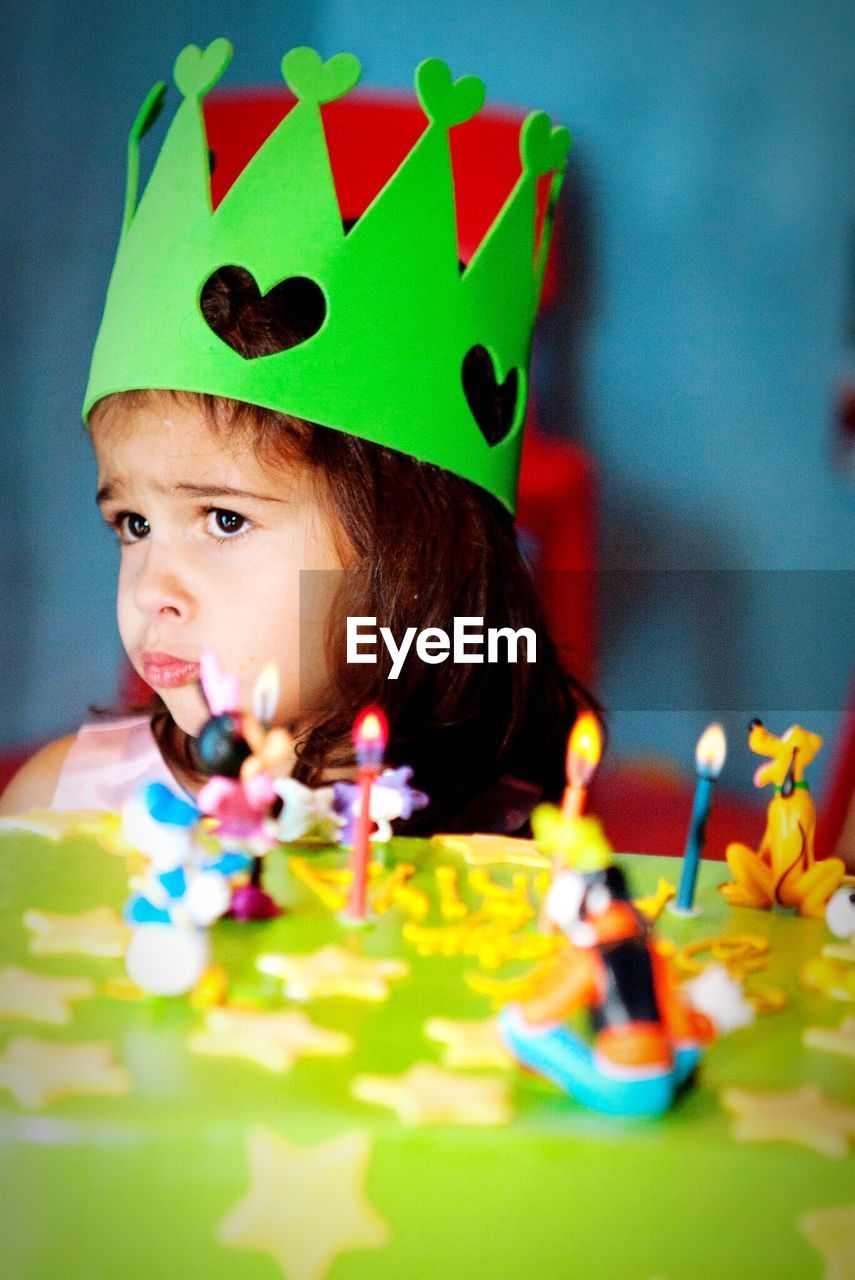 Close-up of girl by birthday cake