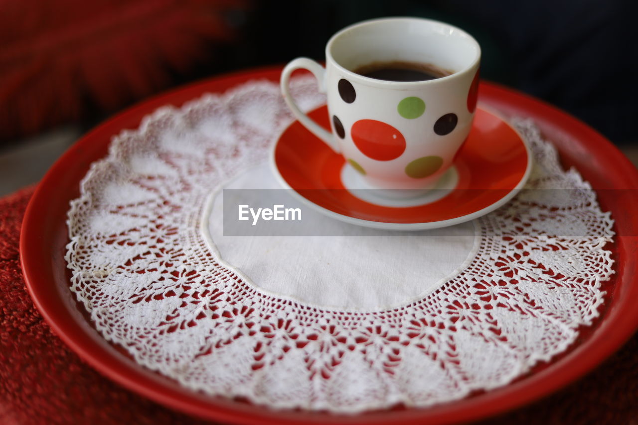 CLOSE-UP OF COFFEE CUP WITH FORK AND SPOON ON TABLE