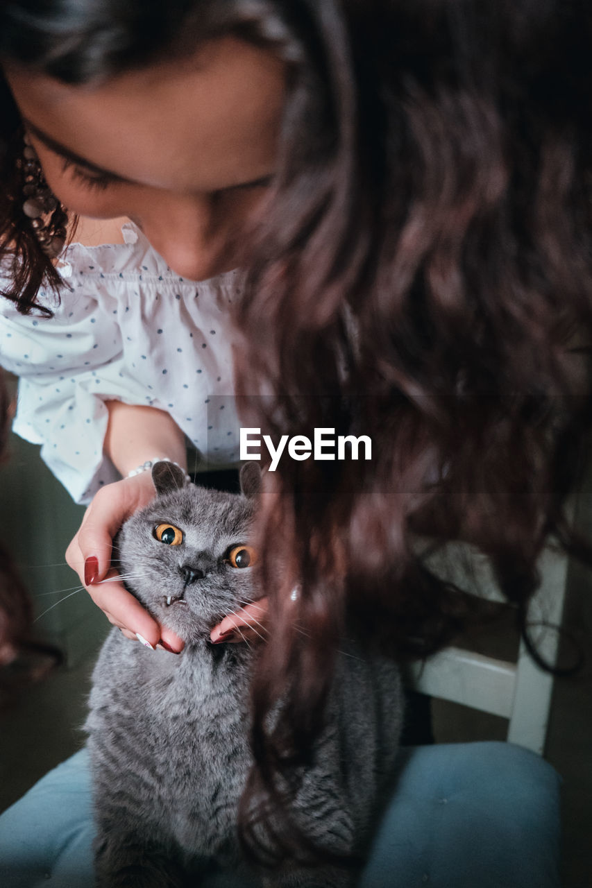 Close-up of young woman with cat at home