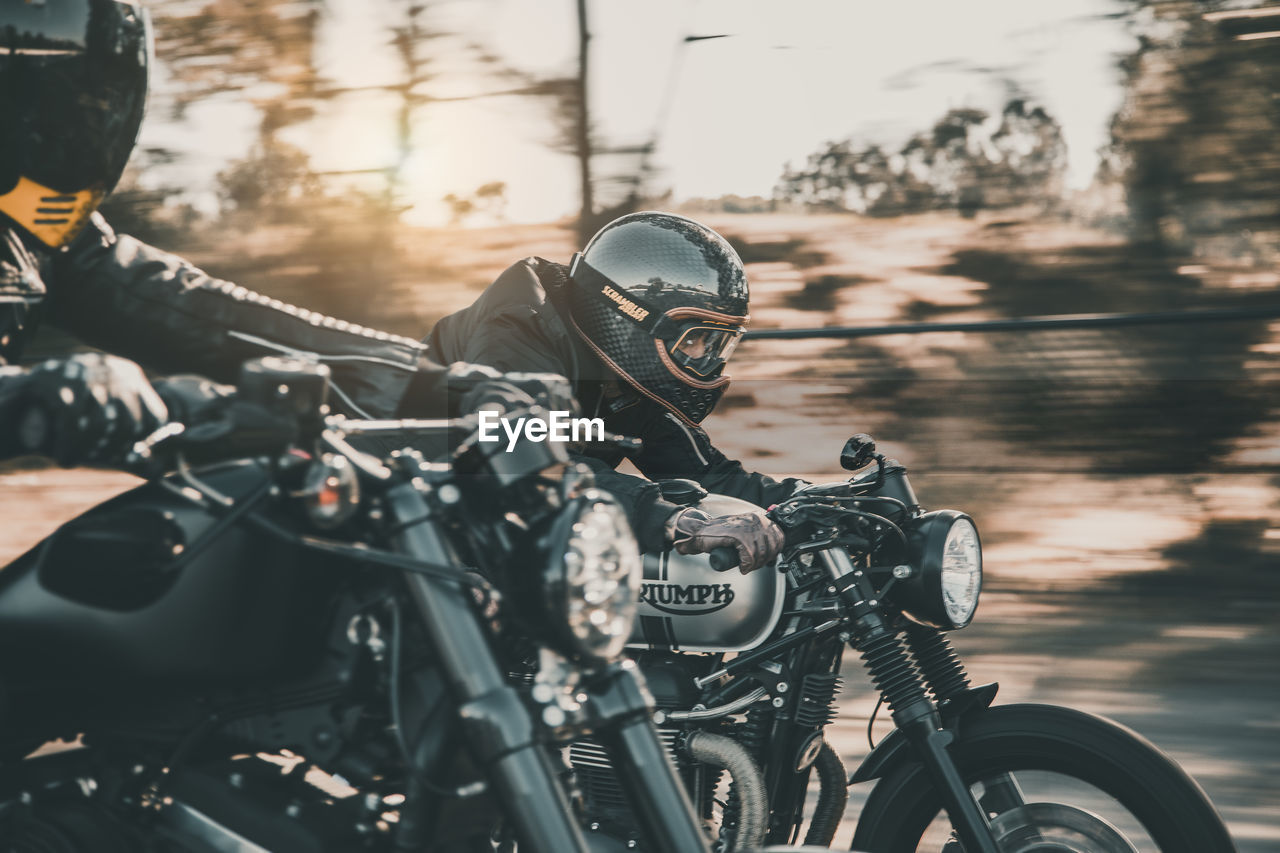 MAN RIDING MOTORCYCLE ON STREET