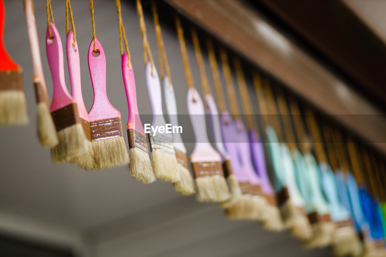 Close-up of multi colored paintbrush hanging for sale