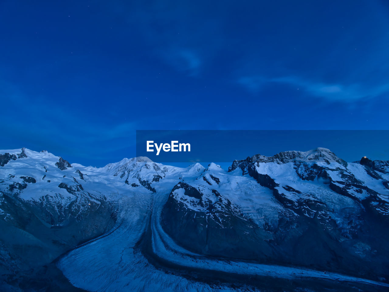 Snow covered mountains against blue sky