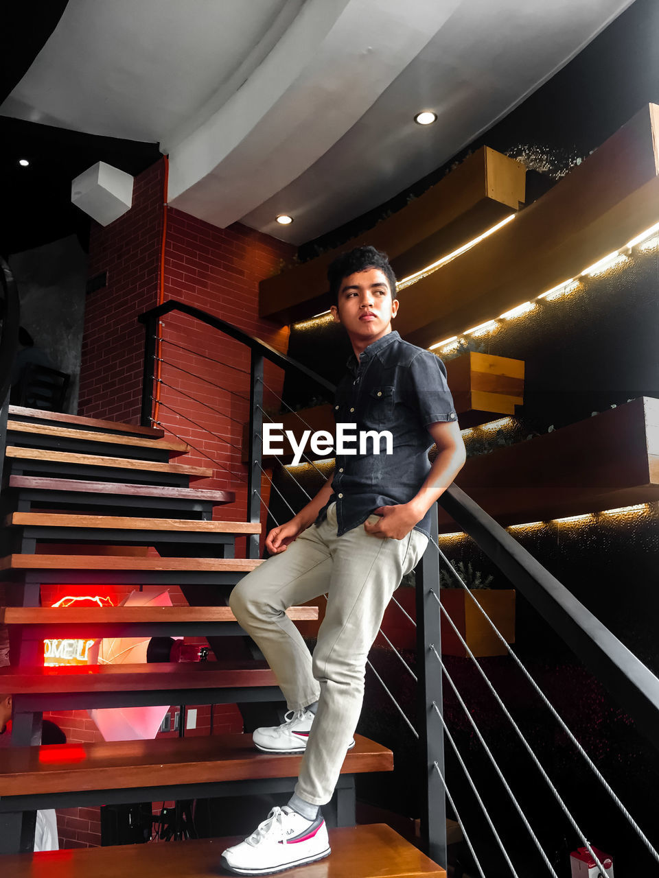 PORTRAIT OF YOUNG MAN STANDING ON STEPS