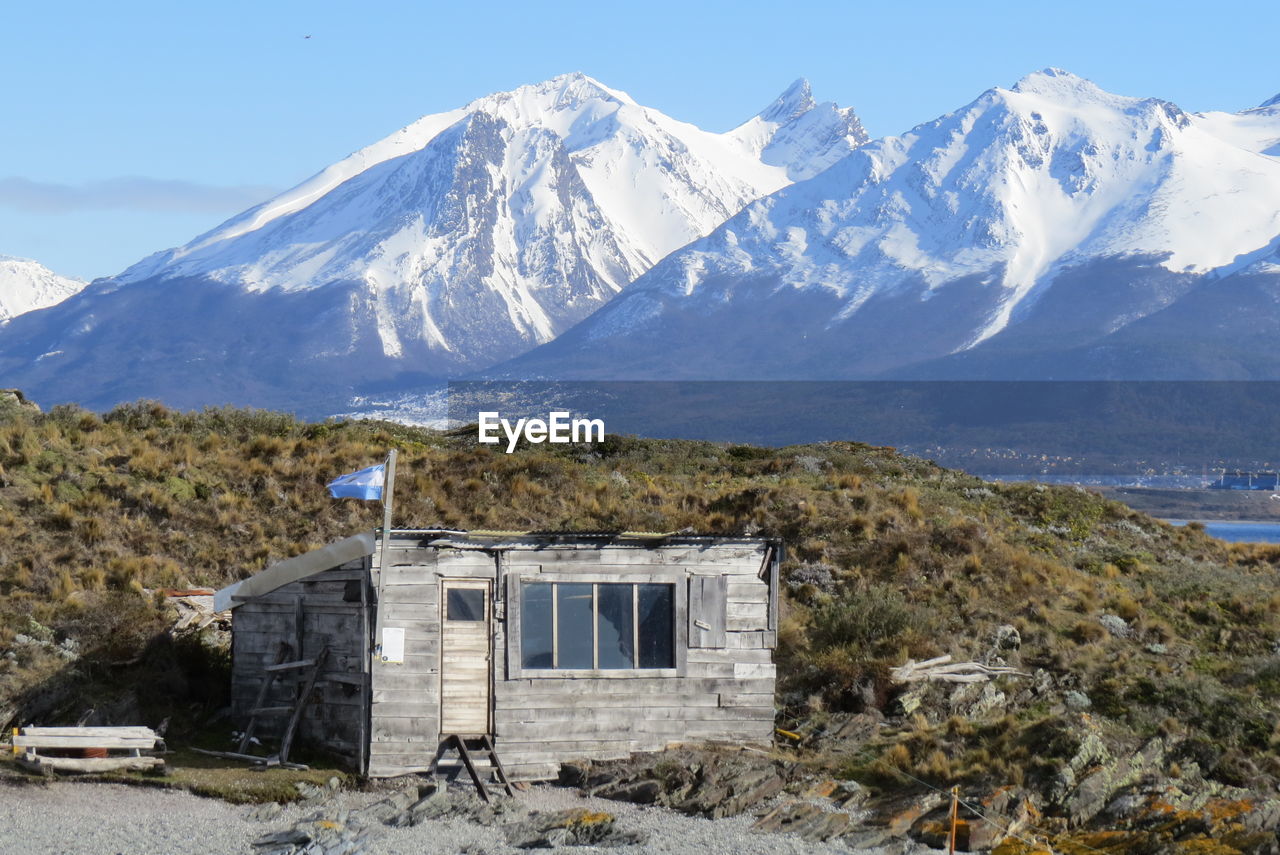 Built structure on snowcapped mountains against sky