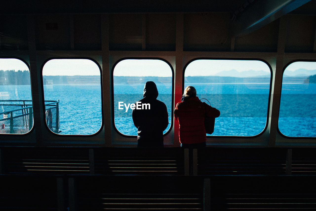 REAR VIEW OF PEOPLE TRAVELING IN BOAT