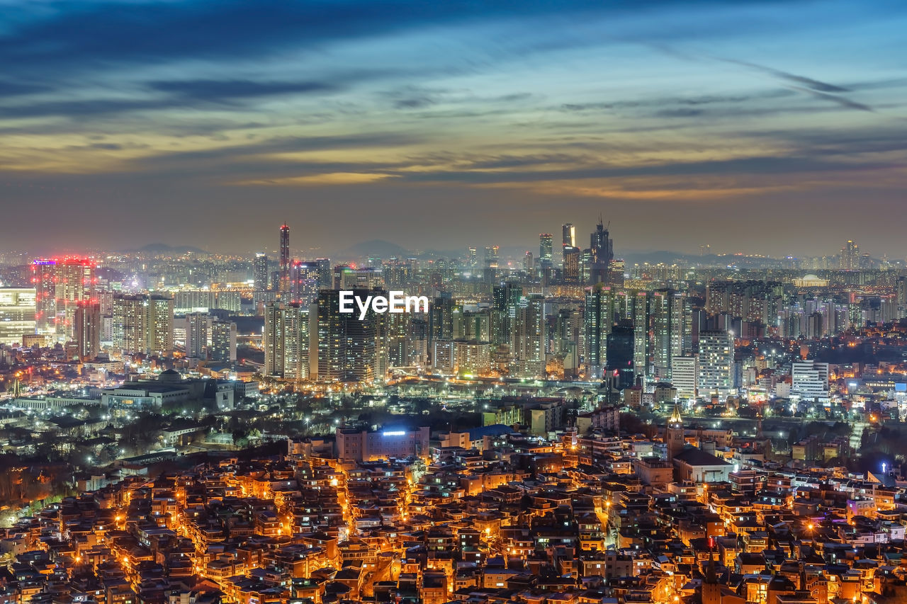 Illuminated cityscape against sky at night