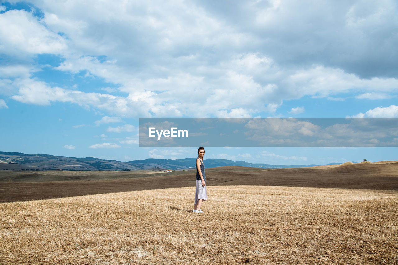 Side view of woman standing on grassy field