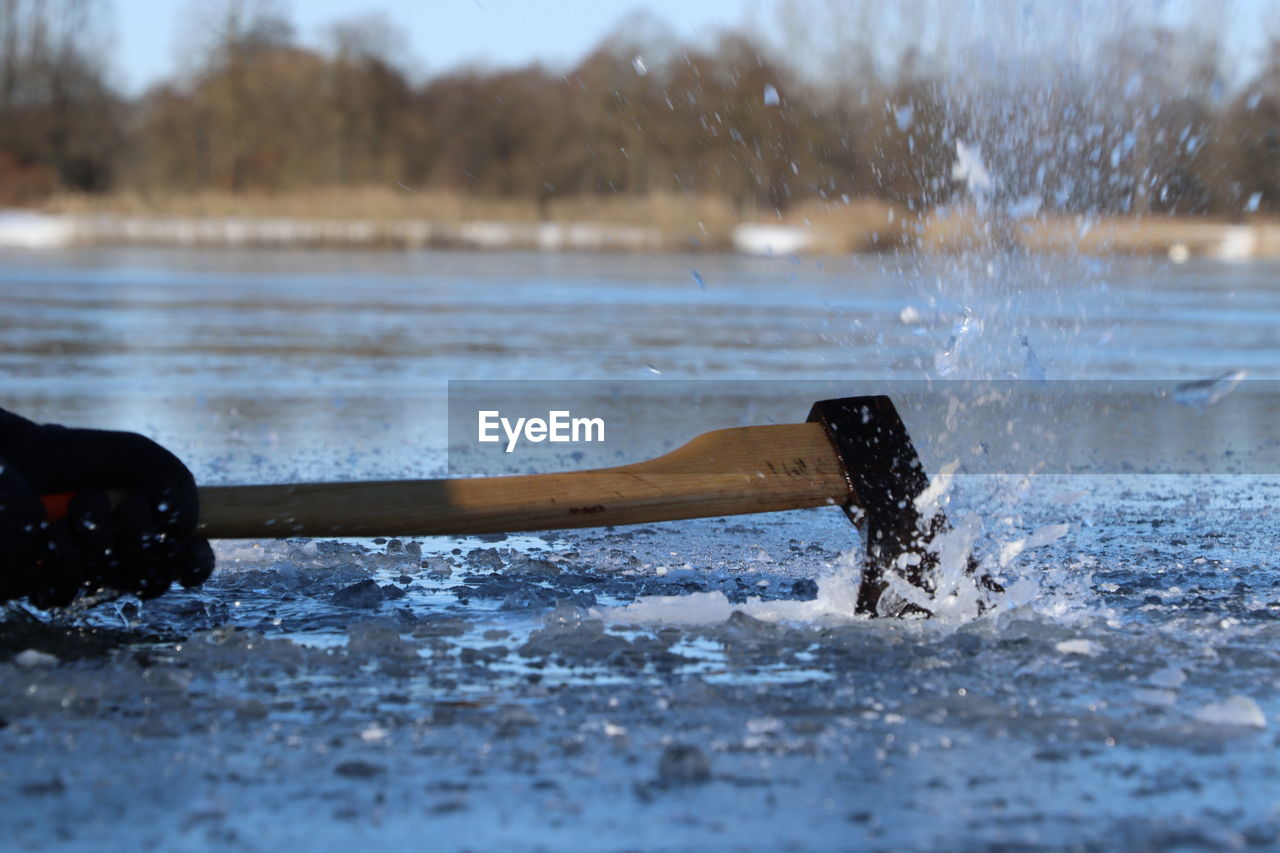 CLOSE-UP OF WATER SPLASHING ON LAND AGAINST TREES