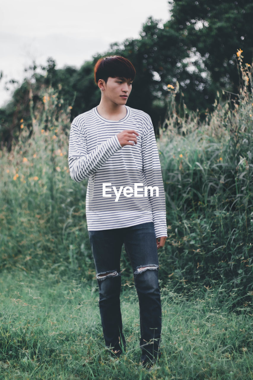 FULL LENGTH OF YOUNG MAN STANDING ON LAND