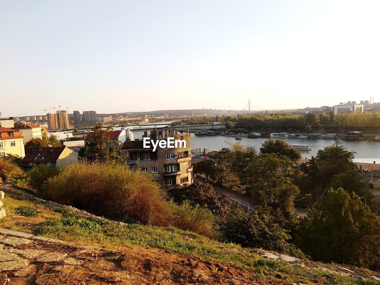 High angle view of buildings by river against clear sky