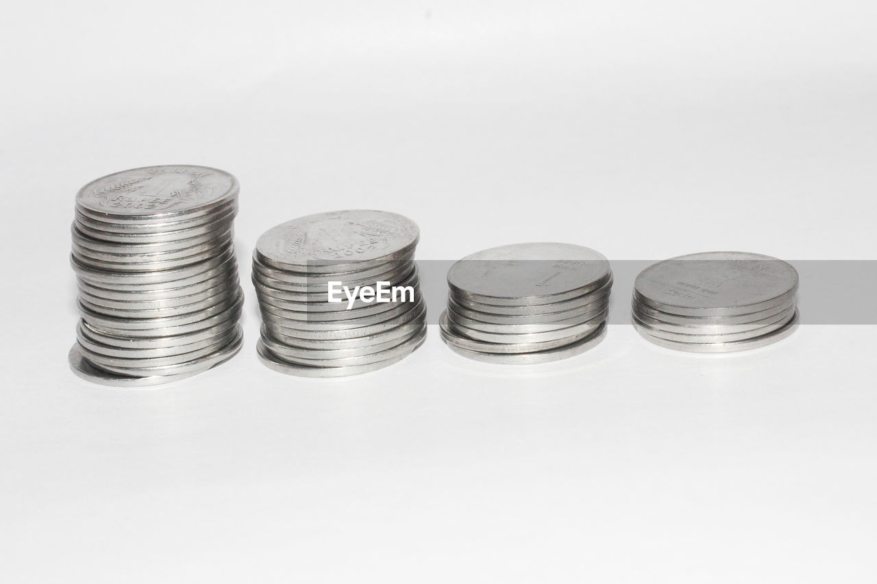 CLOSE-UP OF COINS ON WHITE BACKGROUND