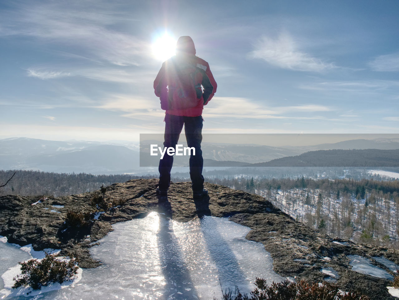 Hiker relaxing on top of hill and enjoying on sunny day. tourist trekking along a hill