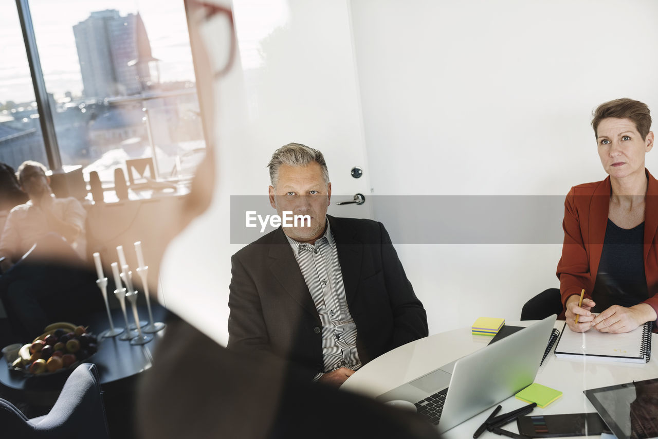 Colleagues in meeting seen through glass