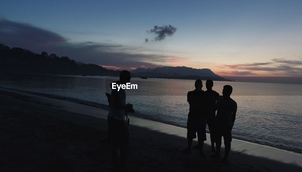 SILHOUETTE PEOPLE AT BEACH DURING SUNSET