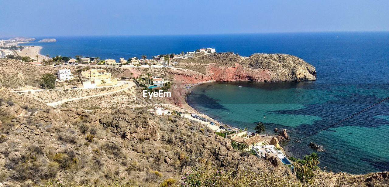 High angle view of beach with horizon, blue sky, blue water