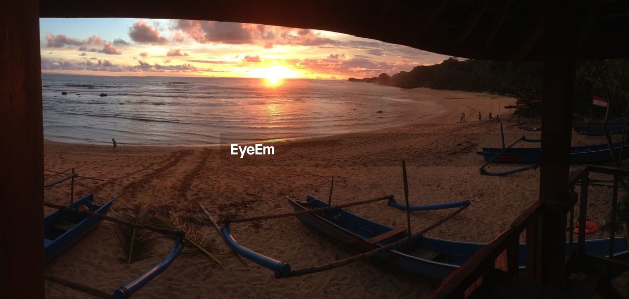 SCENIC VIEW OF BEACH AGAINST SKY AT SUNSET