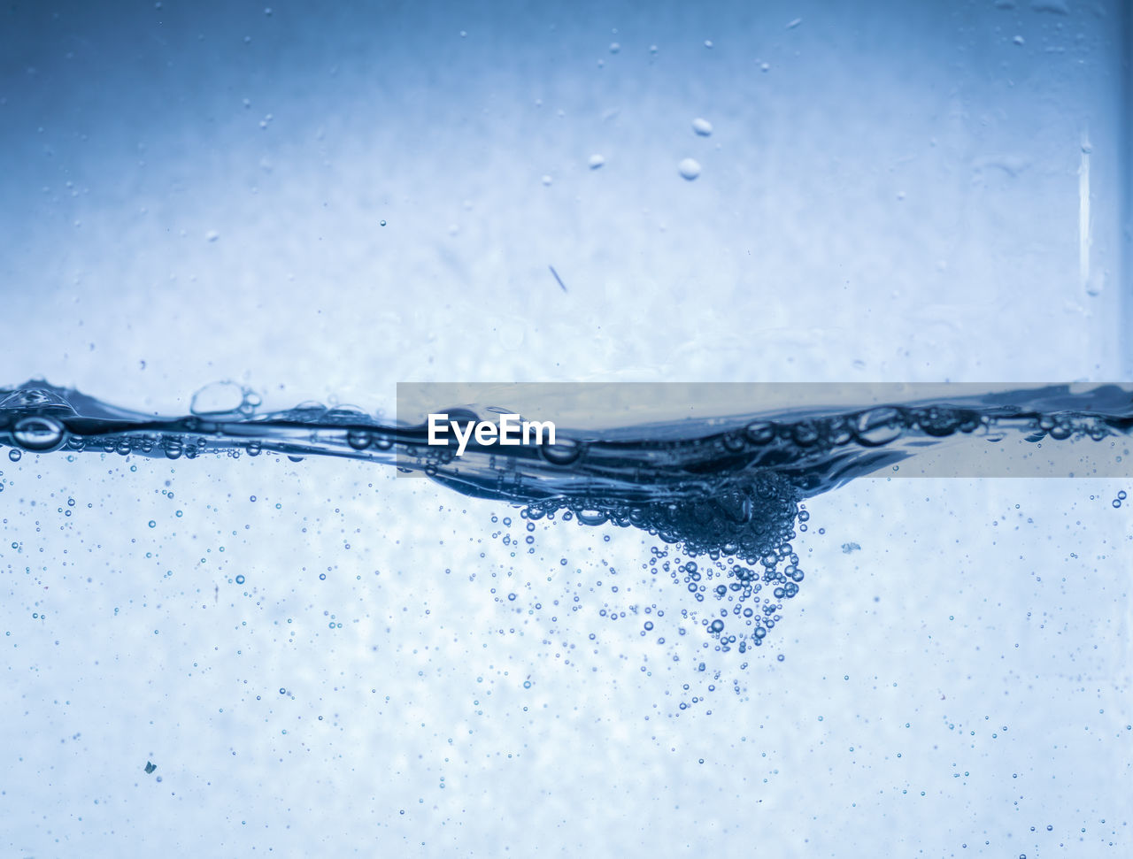 CLOSE-UP OF WET GLASS AGAINST WHITE BACKGROUND