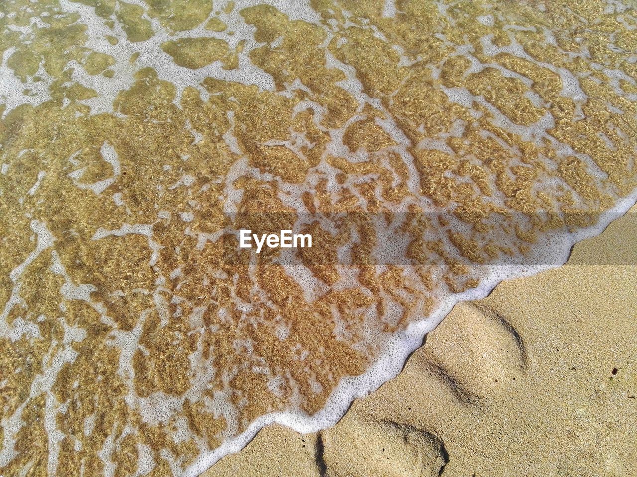 HIGH ANGLE VIEW OF SAND ON BEACH