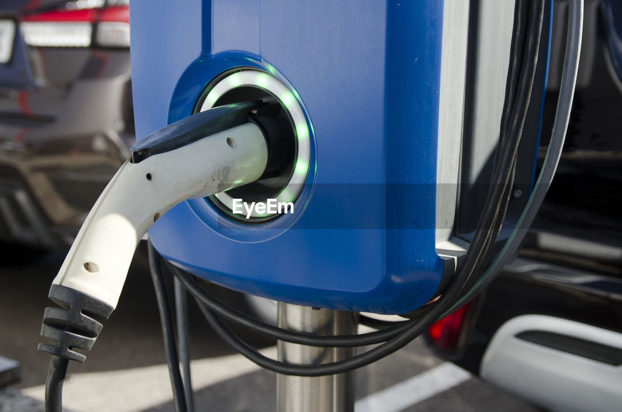 Close-up modern electric commercial van car plugged with fast charger at charging station. eco