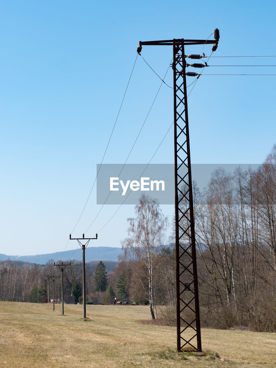 Power line towers against sky background. old fashion electric poles against blue sky, rusty metal