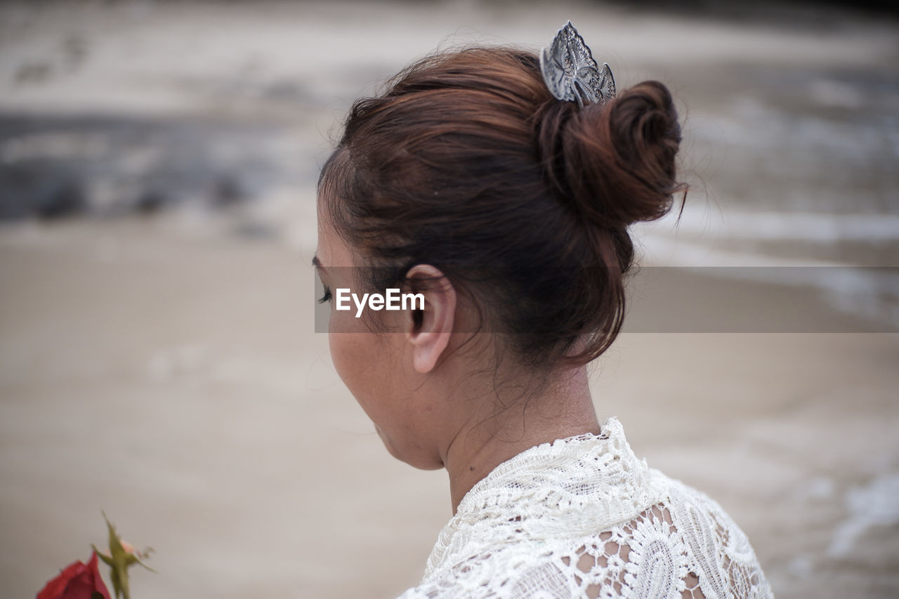 REAR VIEW OF WOMAN AT BEACH DURING RAINY SEASON