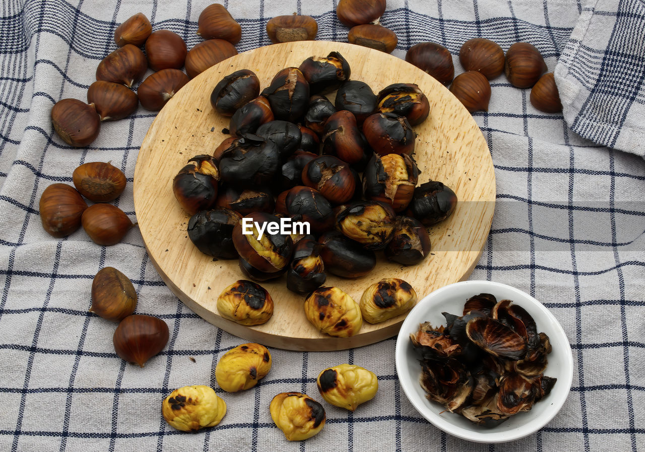 Fresh roasted chestnuts on a table with peels.