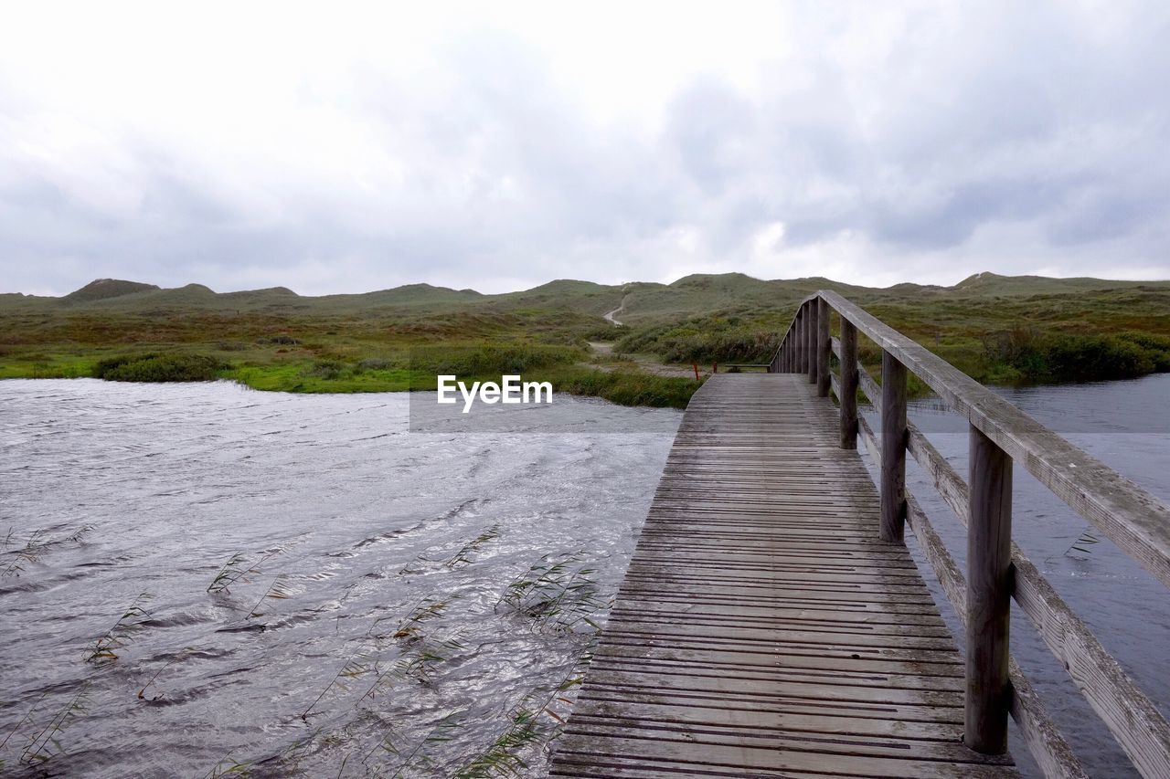 WOODEN FOOTBRIDGE LEADING TOWARDS MOUNTAINS