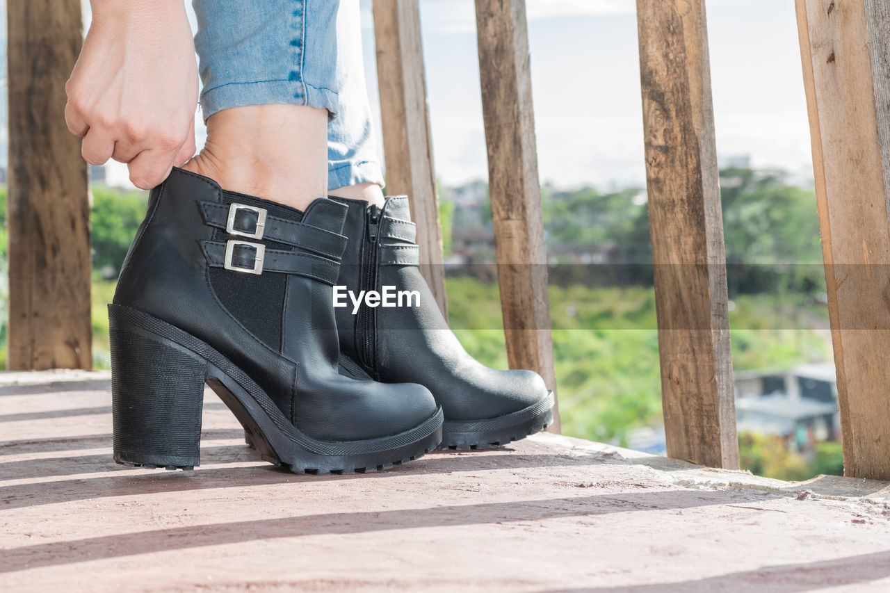 footwear, adult, one person, shoe, day, human leg, spring, women, lifestyles, low section, limb, human limb, outdoors, nature, leather, clothing, high heels, casual clothing, leisure activity, sunlight, sports, young adult, standing, men, boot, female, fashion, focus on foreground