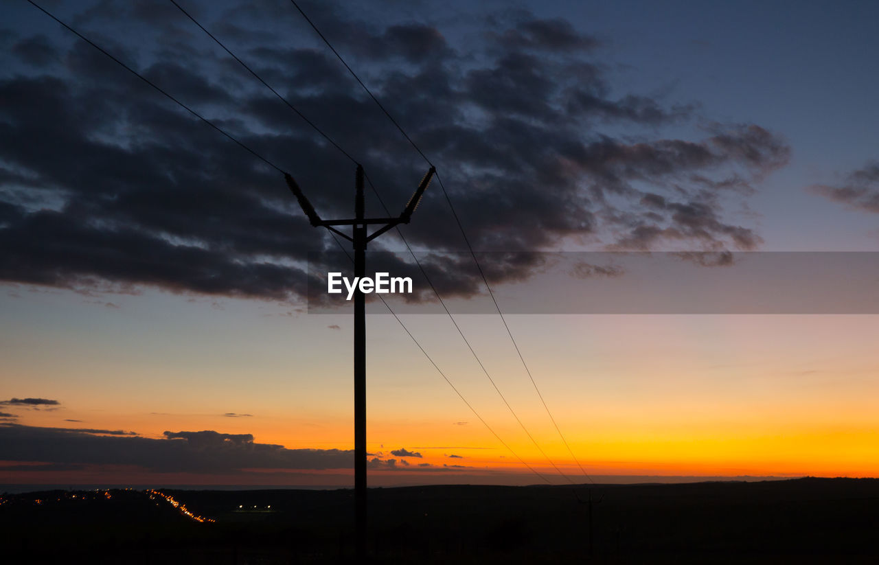 LOW ANGLE VIEW OF SILHOUETTE ELECTRICITY PYLON AGAINST SKY DURING SUNSET
