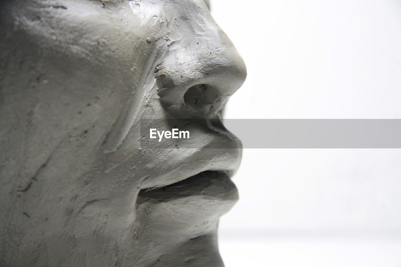 Detail of the female profile. clay face sculpture, on white background.