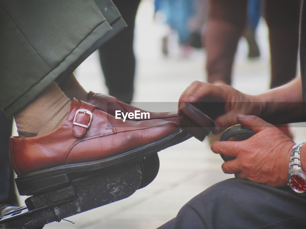 Close-up of man shining shoes outdoors