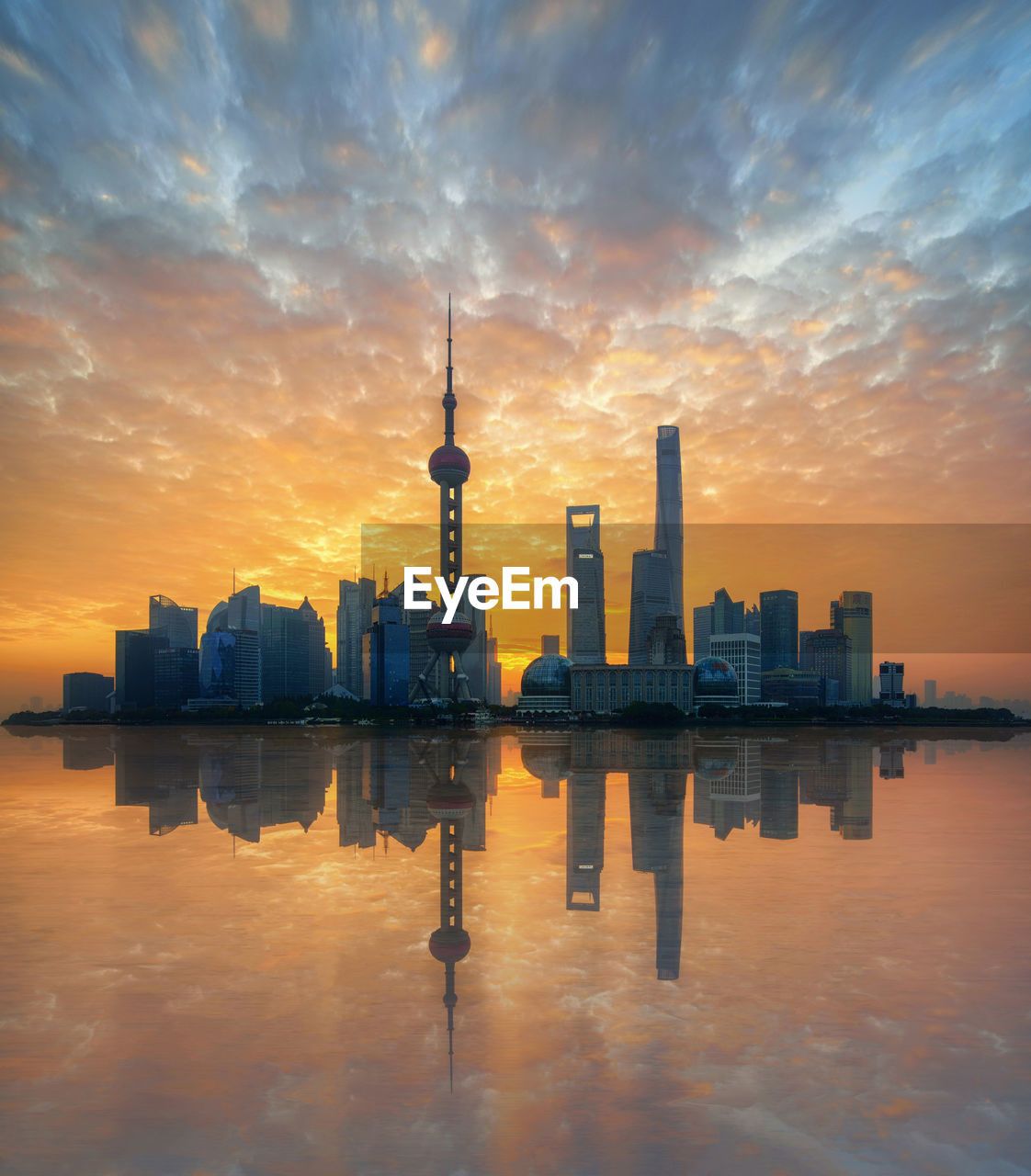 Reflection of buildings in city during sunset