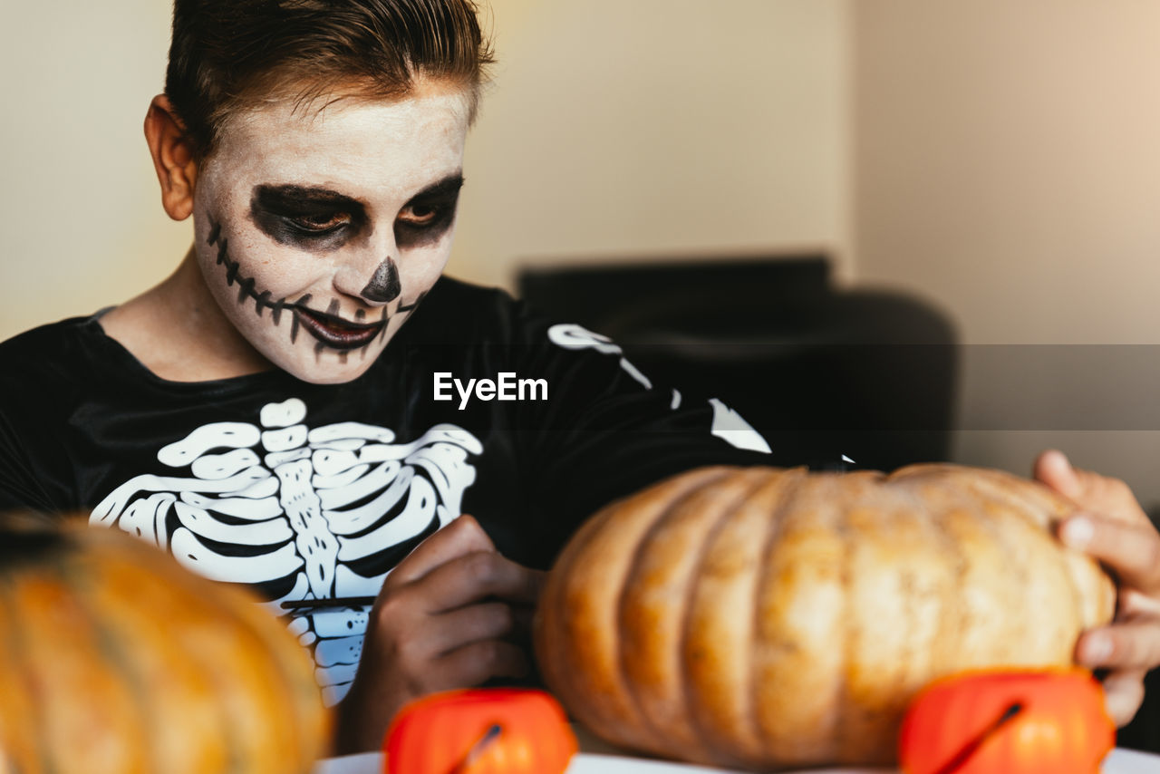 Midsection of man with pumpkin in halloween