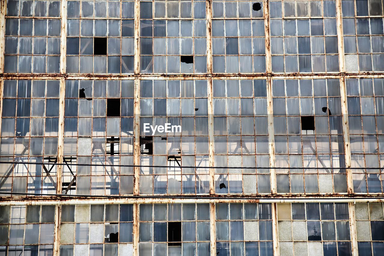 Wall of broken windows in abandoned factory