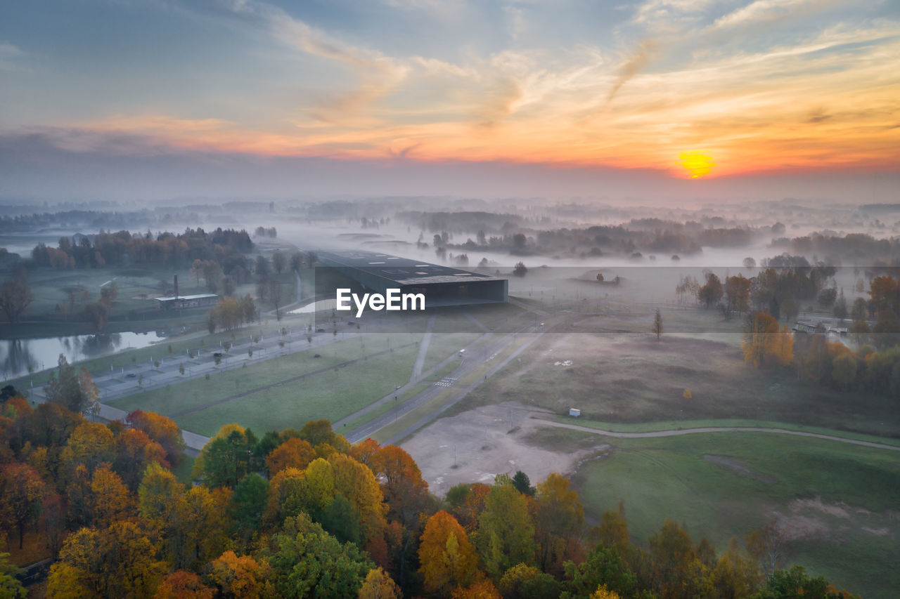 HIGH ANGLE VIEW OF TREES AGAINST SKY AT SUNSET