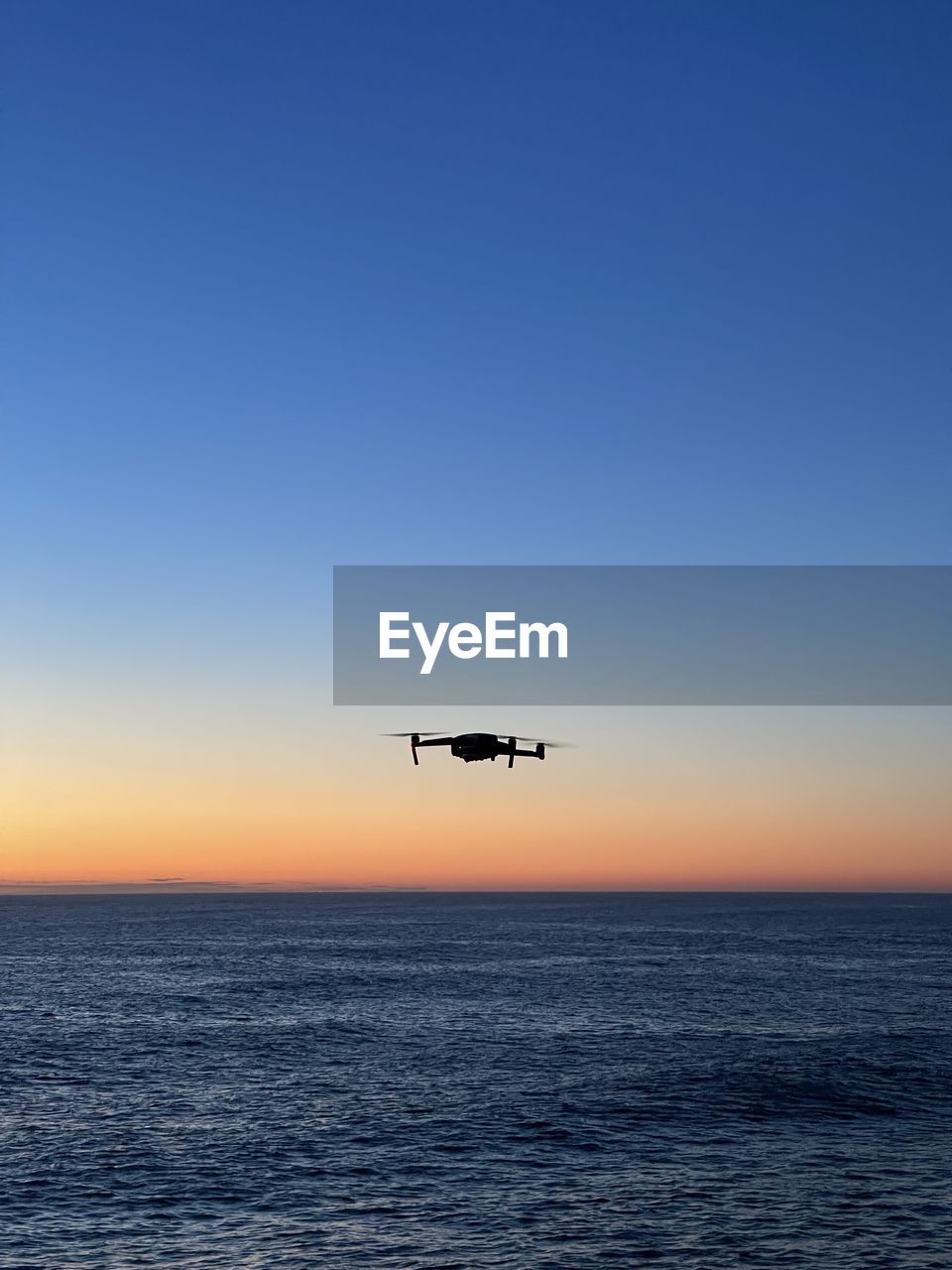 Drone flying over sea during sunrise 