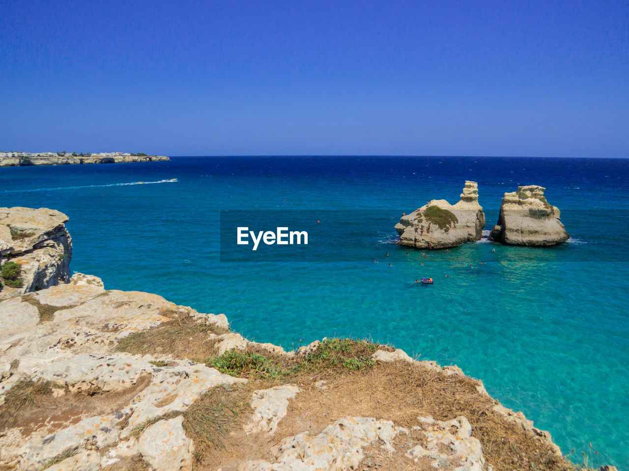 ROCKS IN SEA AGAINST CLEAR SKY