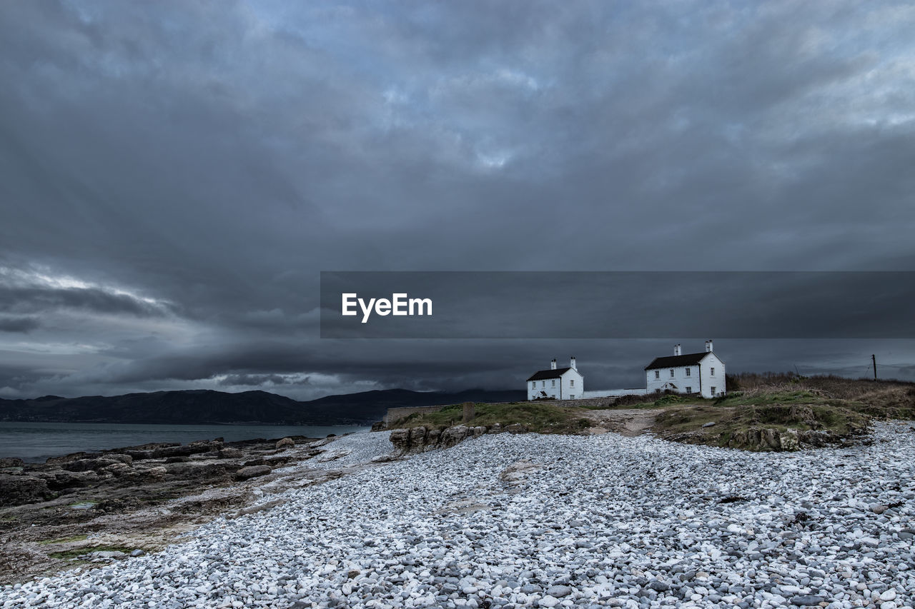 Cloudy sky at sunset over the two cottages at penmon point near the lighthouse 