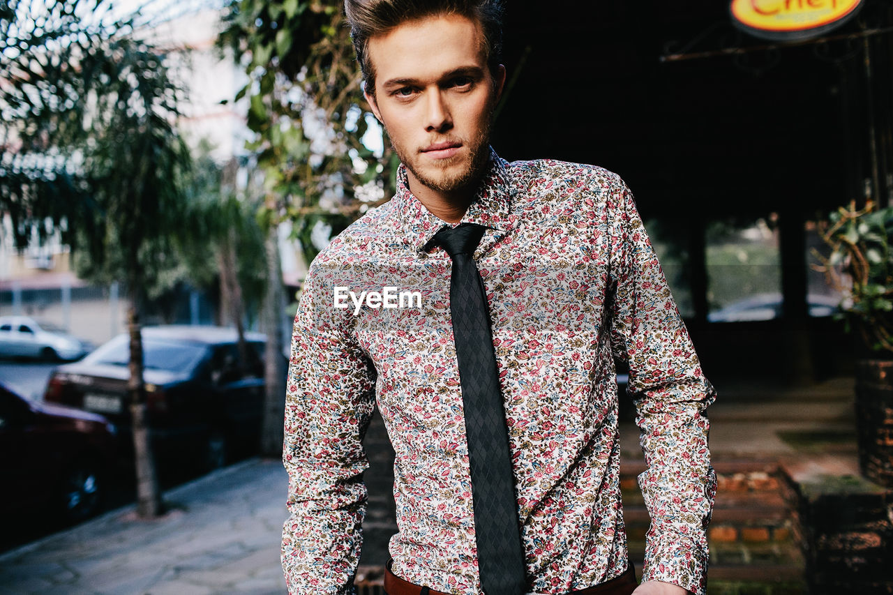 Portrait of young man in formalwear standing outdoors