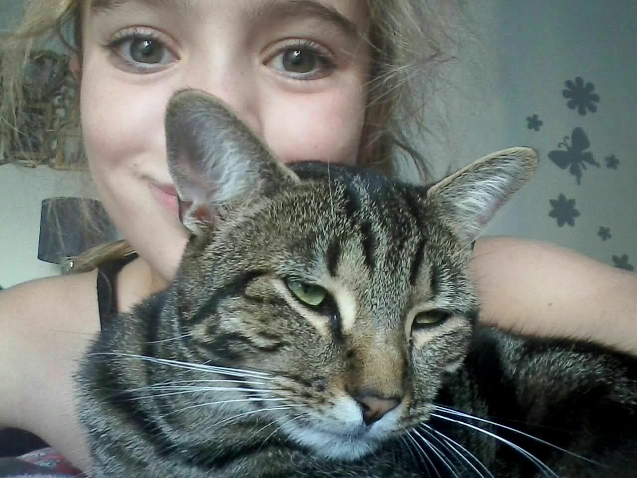 CLOSE-UP PORTRAIT OF YOUNG WOMAN HOLDING CAT WITH EYES