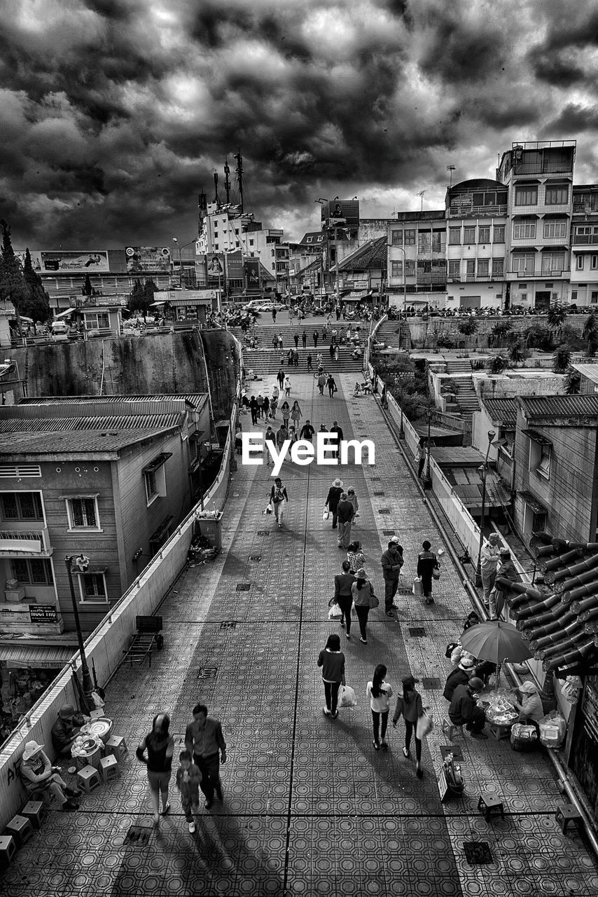 High angle view of people in city against cloudy sky