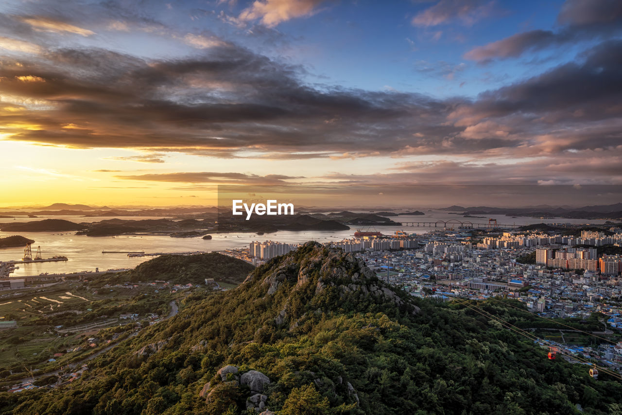 HIGH ANGLE SHOT OF TOWNSCAPE AGAINST SKY DURING SUNSET