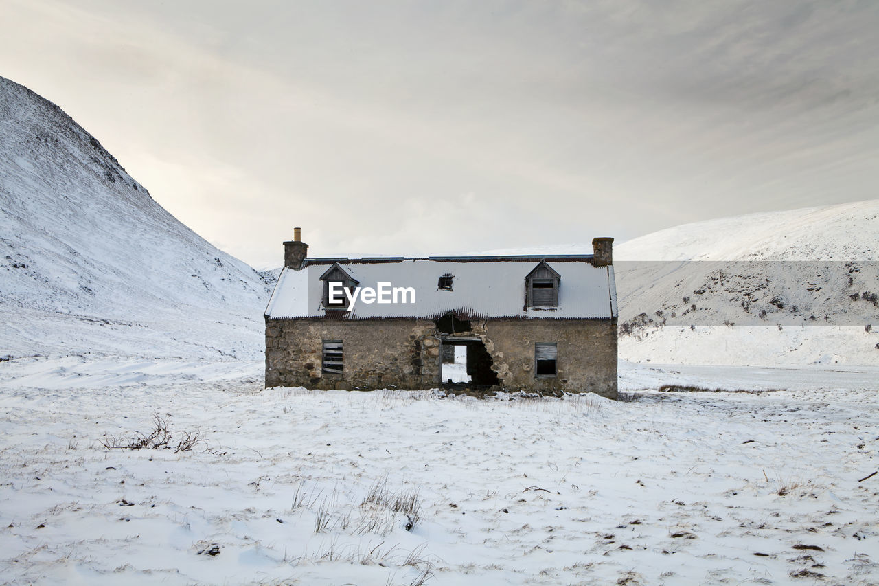 Built structure on snow covered land against sky