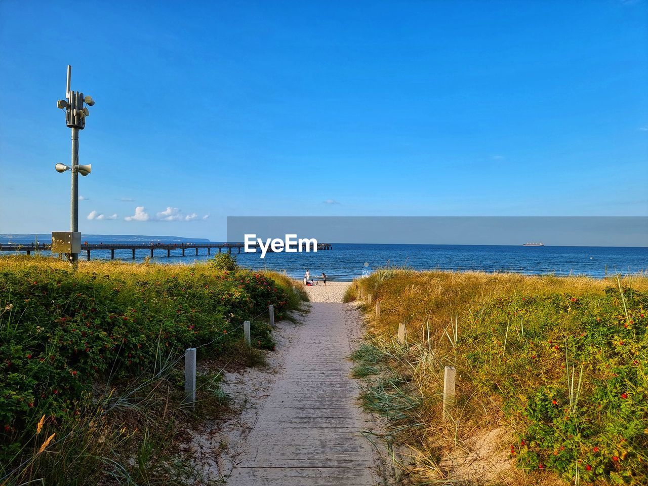 sky, sea, coast, water, shore, horizon, land, beach, nature, horizon over water, walkway, ocean, scenics - nature, beauty in nature, plant, tranquility, blue, body of water, footpath, tranquil scene, no people, the way forward, grass, clear sky, day, vacation, travel destinations, outdoors, boardwalk, landscape, idyllic, architecture, bay, travel, cloud, coastline, environment, non-urban scene, tower, sand, tourism, road, transportation, sunlight, holiday, morning, sunny, guidance