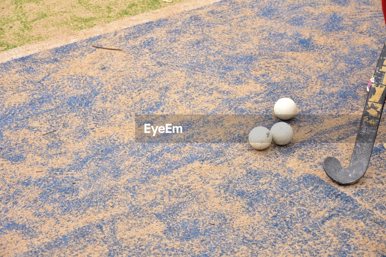 High angle view of hockey stick and balls on field