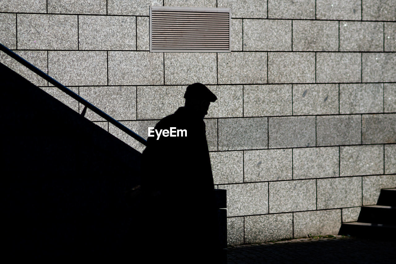 Shadow of man moving down steps