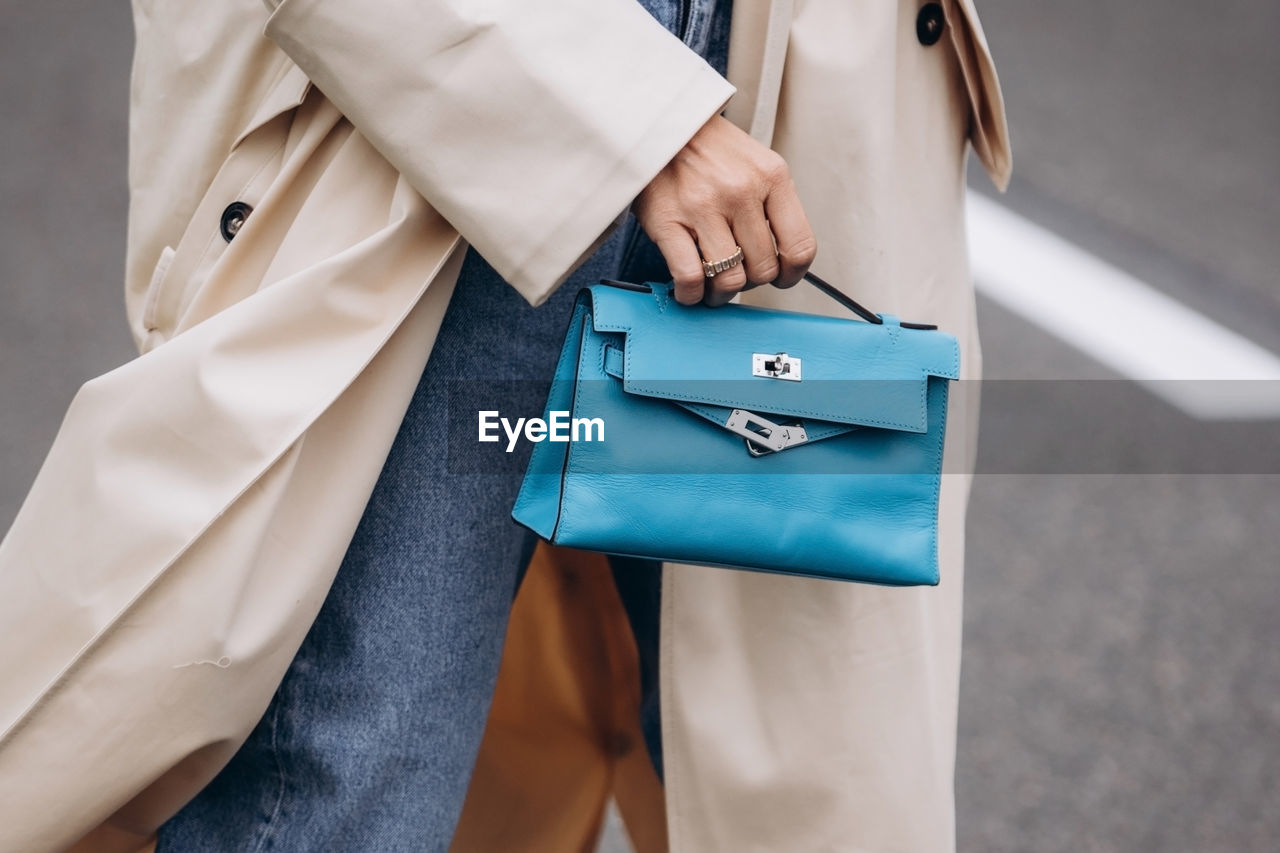 midsection of female doctor holding shopping bags